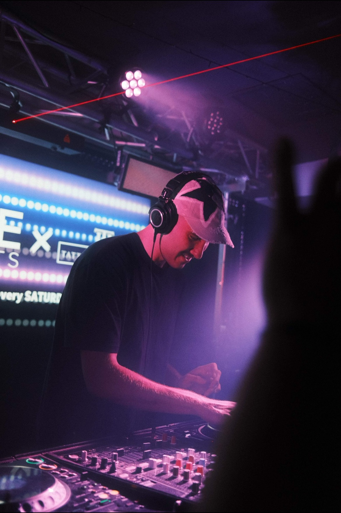 Nick DJing under purple club lighting
